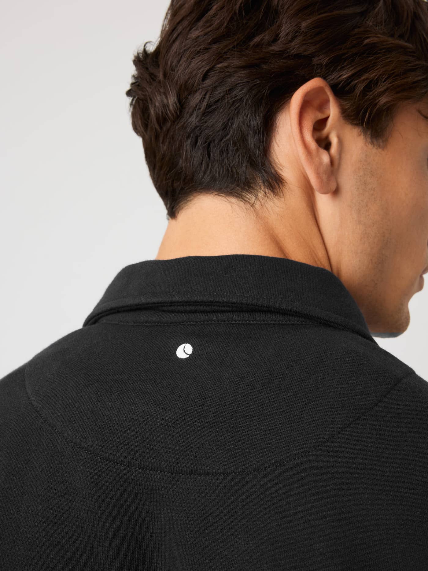 Back neck detail of the Borg Classic Polo Sweatshirt in Black Beauty (Black) with white tennis ball embroidery. - Image 4