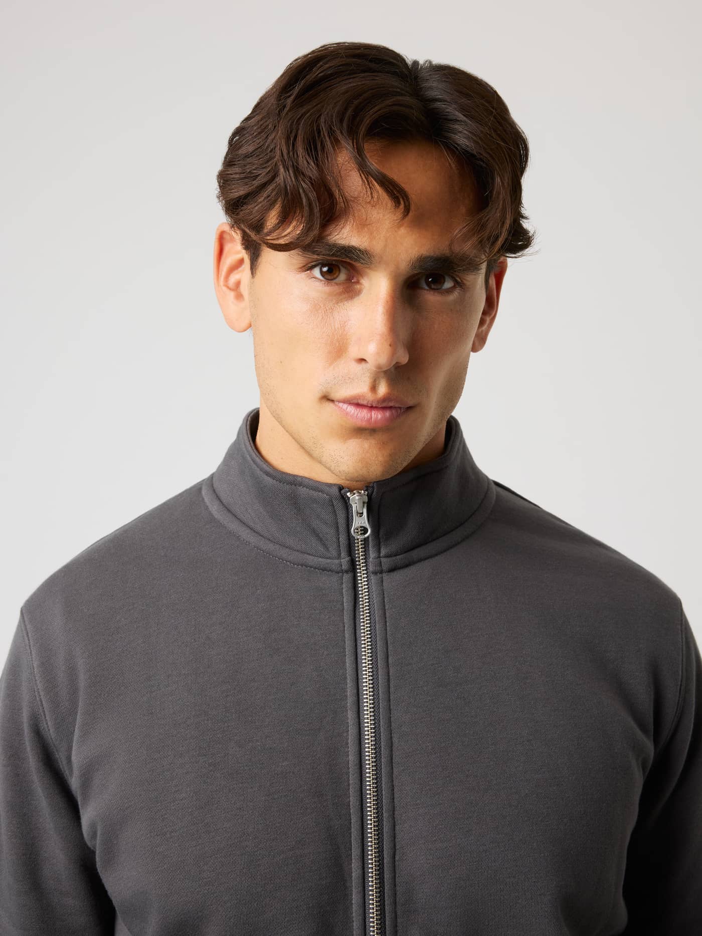 Close-up of the Centre Full Zip Sweatshirt in Asphalt (Black) featuring a metal front zipper and high collar. - Image 4