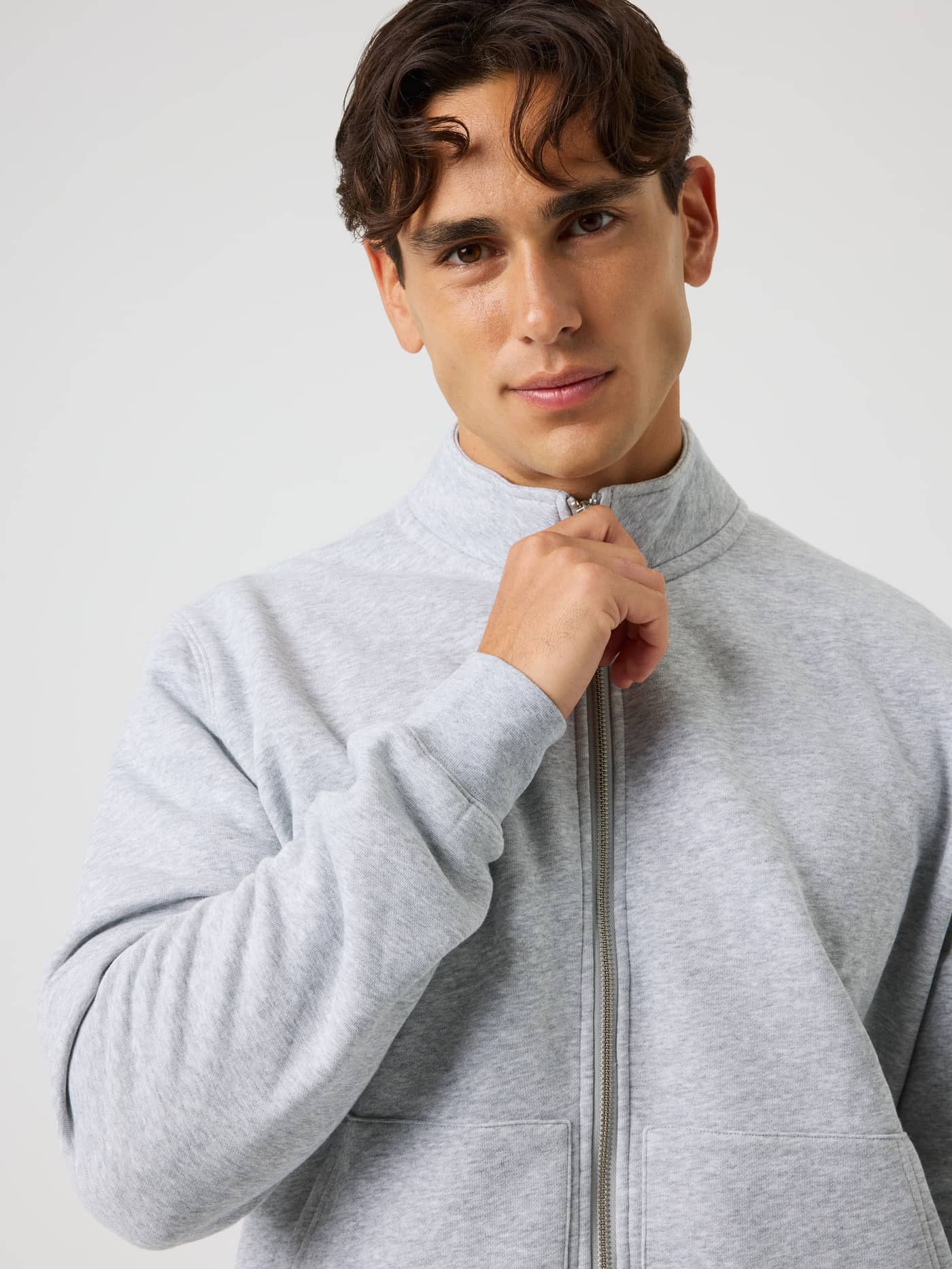 Close-up front view of the Centre Full Zip Sweatshirt in Light Grey Melange (Grey) with a high collar and metal zipper. - Image 4
