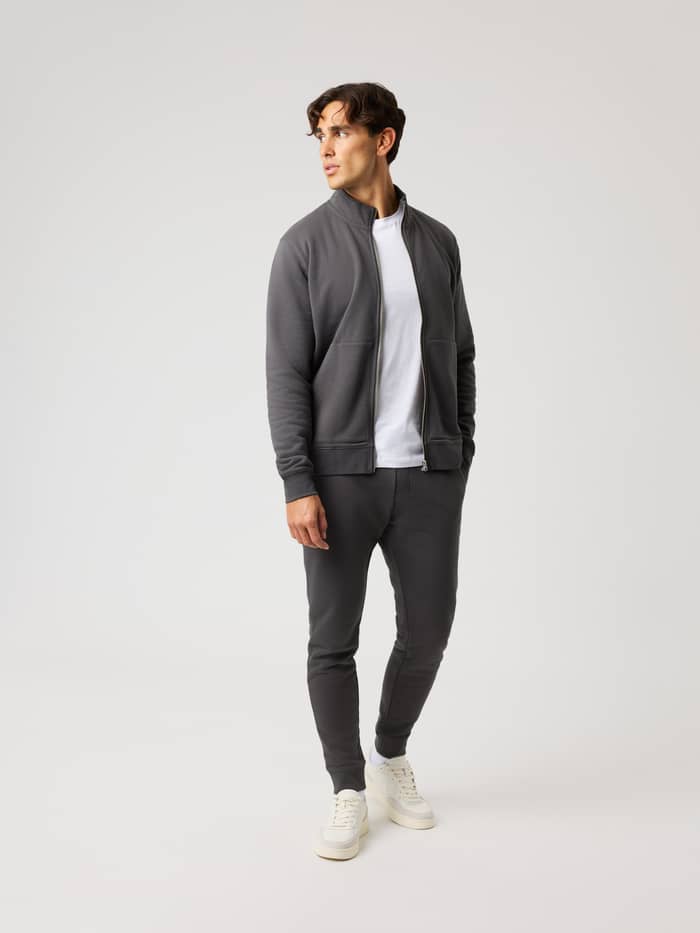 Full-body view of a model wearing the Centre Full Zip Sweatshirt in Asphalt (Black) with a regular fit and metal zipper. - Image 3
