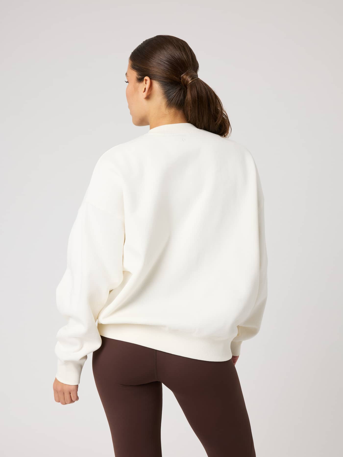 Back view of the Studio Oversized Sweatshirt in Tofu (White) with a relaxed fit and dropped shoulders for tennis or leisure. - Image 6