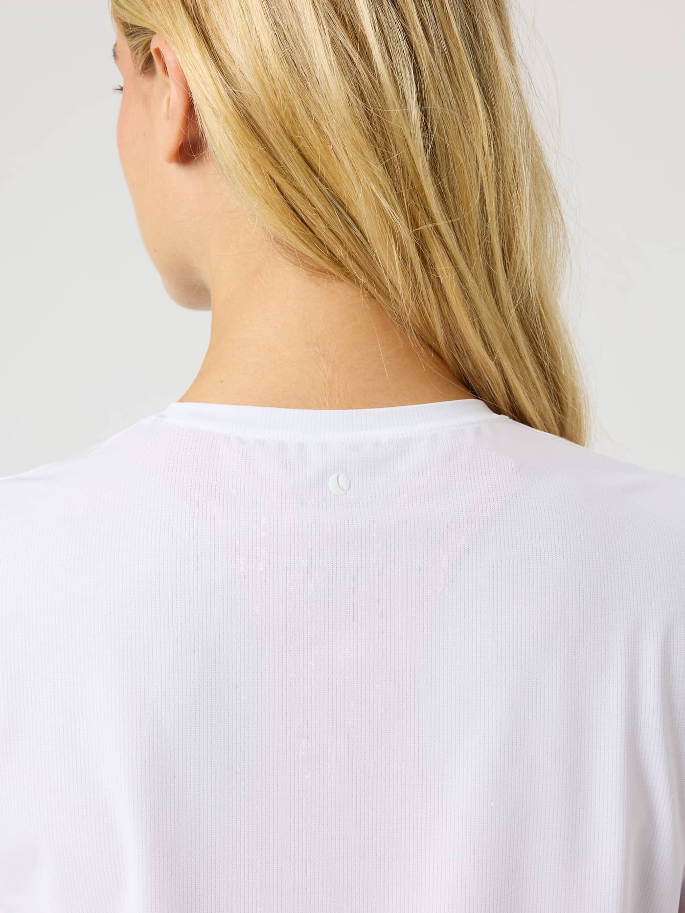 Close-up back view of the Borg Cropped T-Shirt in Brilliant White (White) with a subtle tennis ball print for training. - Image 5