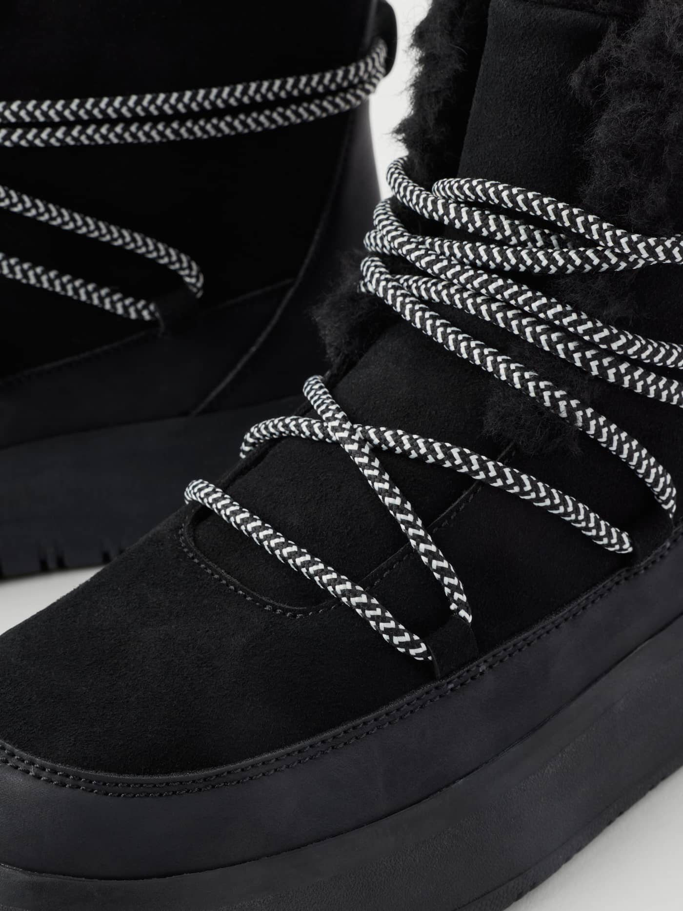 Close-up of Women's Wooly Lace Up Boots in Black featuring patterned laces and a soft wooly lining. - Image 3