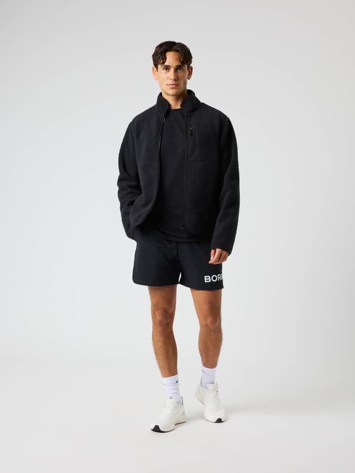 Full-body front view of a man wearing the Borg Pile Jacket in Black Beauty (Black), a warm fleece for training and movement. - Image 3
