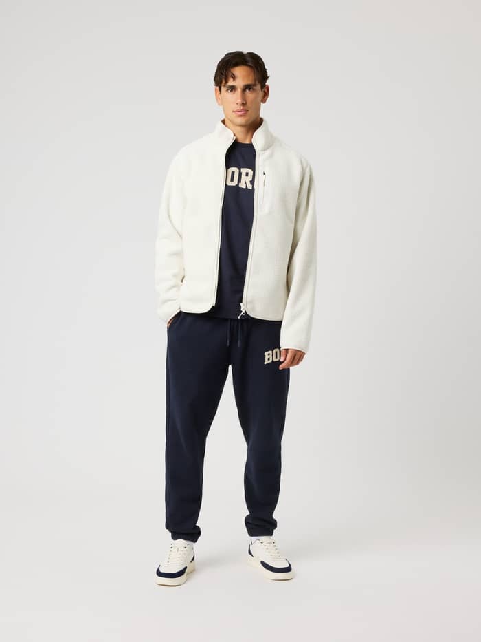 Full-body front view of a model in the Borg Pile Jacket in Tofu (White), a recycled fleece layer for training and tennis. - Image 3