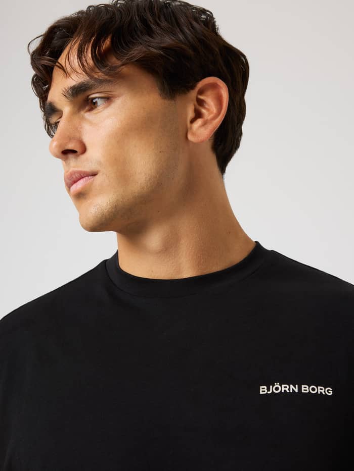 Nahaufnahme des Borg Gym Sleeveless T-Shirt in Black Beauty (Schwarz) mit weißem Logo für Training und Tennis. - Image 4
