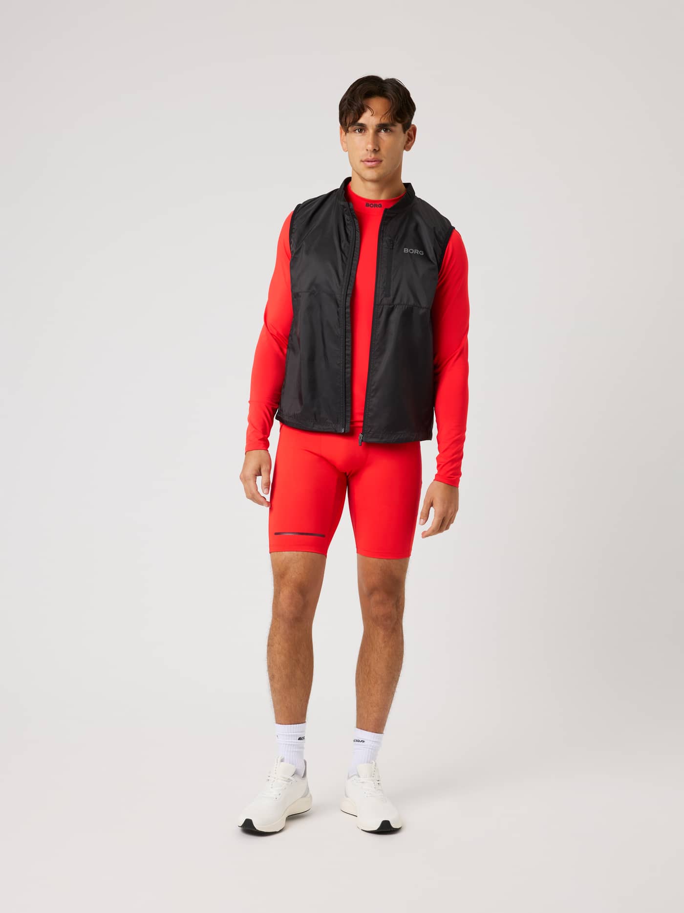 Borg Performance Vest in Black Beauty (Black) worn over red layers in a full-body front view for a technical running look. - Image 3