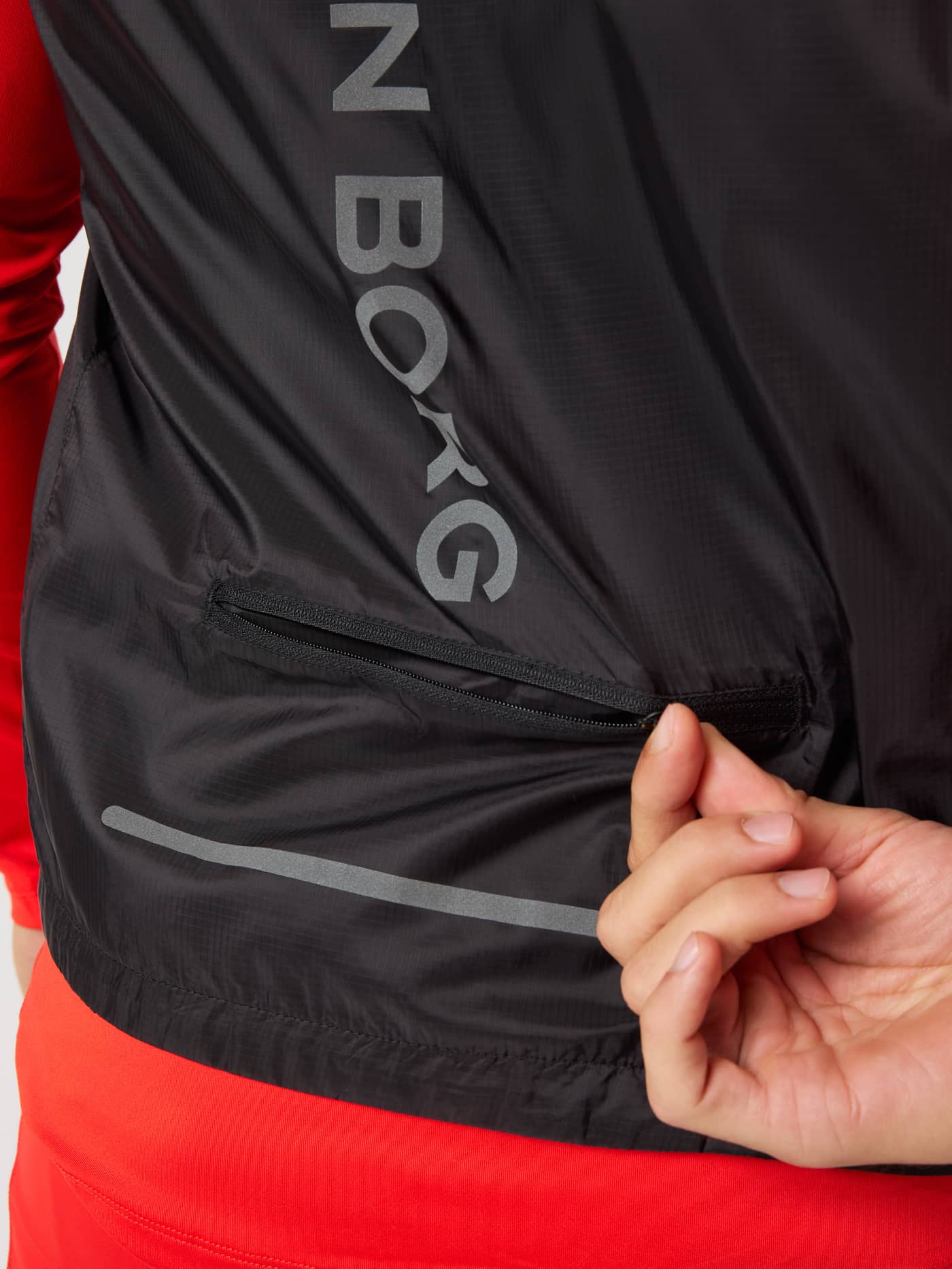 Back view of the Borg Performance Vest in Black Beauty (Black) with a grey logo and zipped pocket for running. - Image 4
