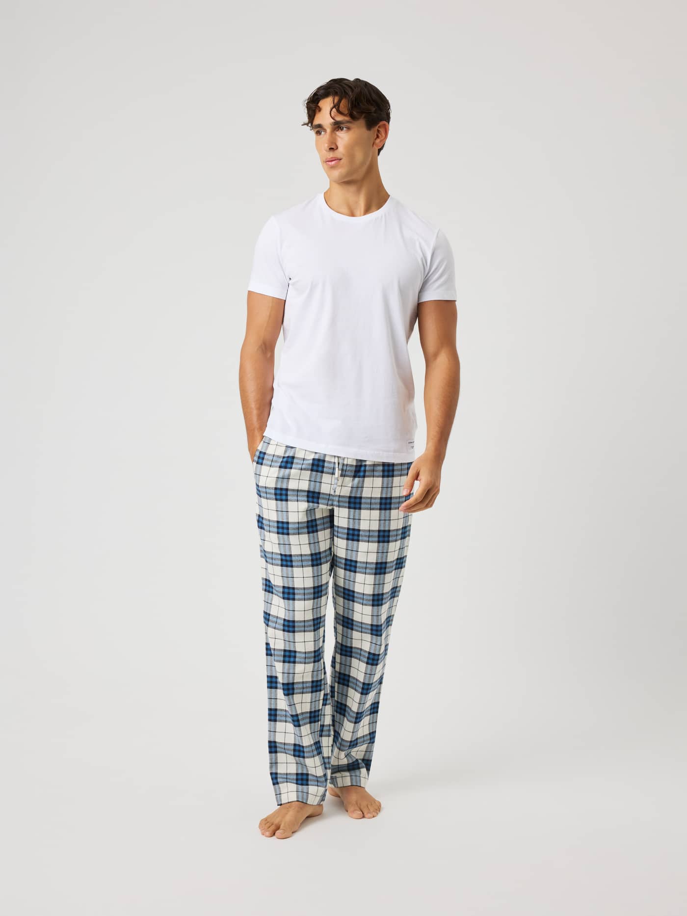 Front view of a man in Core Flannel Pyjama Pants in Tri Tartan 1 (Multi) with a blue and white brushed flannel check. - Image 3