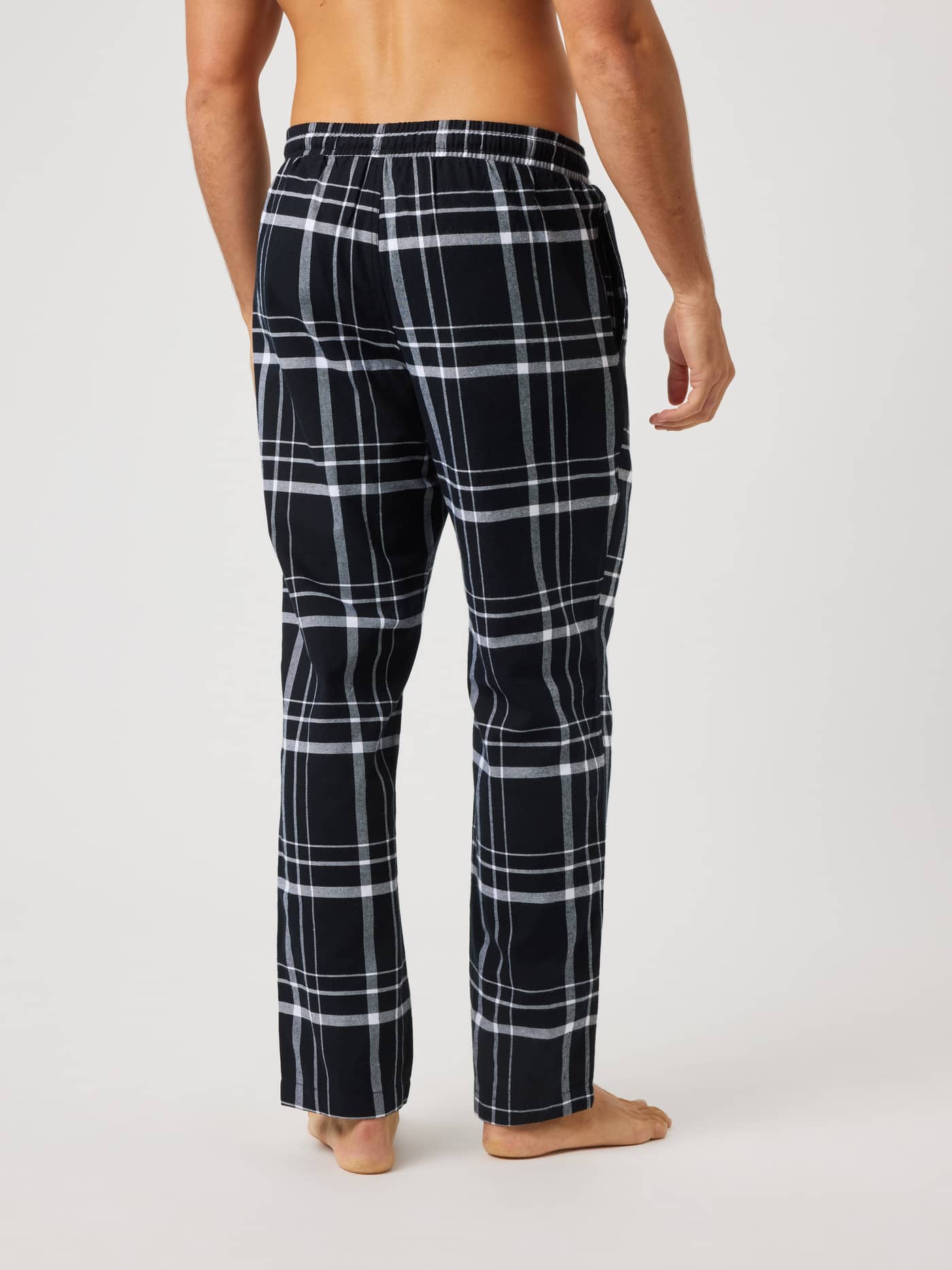 Back view of Core Flannel Pyjama Pants in a black and white check pattern for a relaxed fit and premium comfort. - Image 2