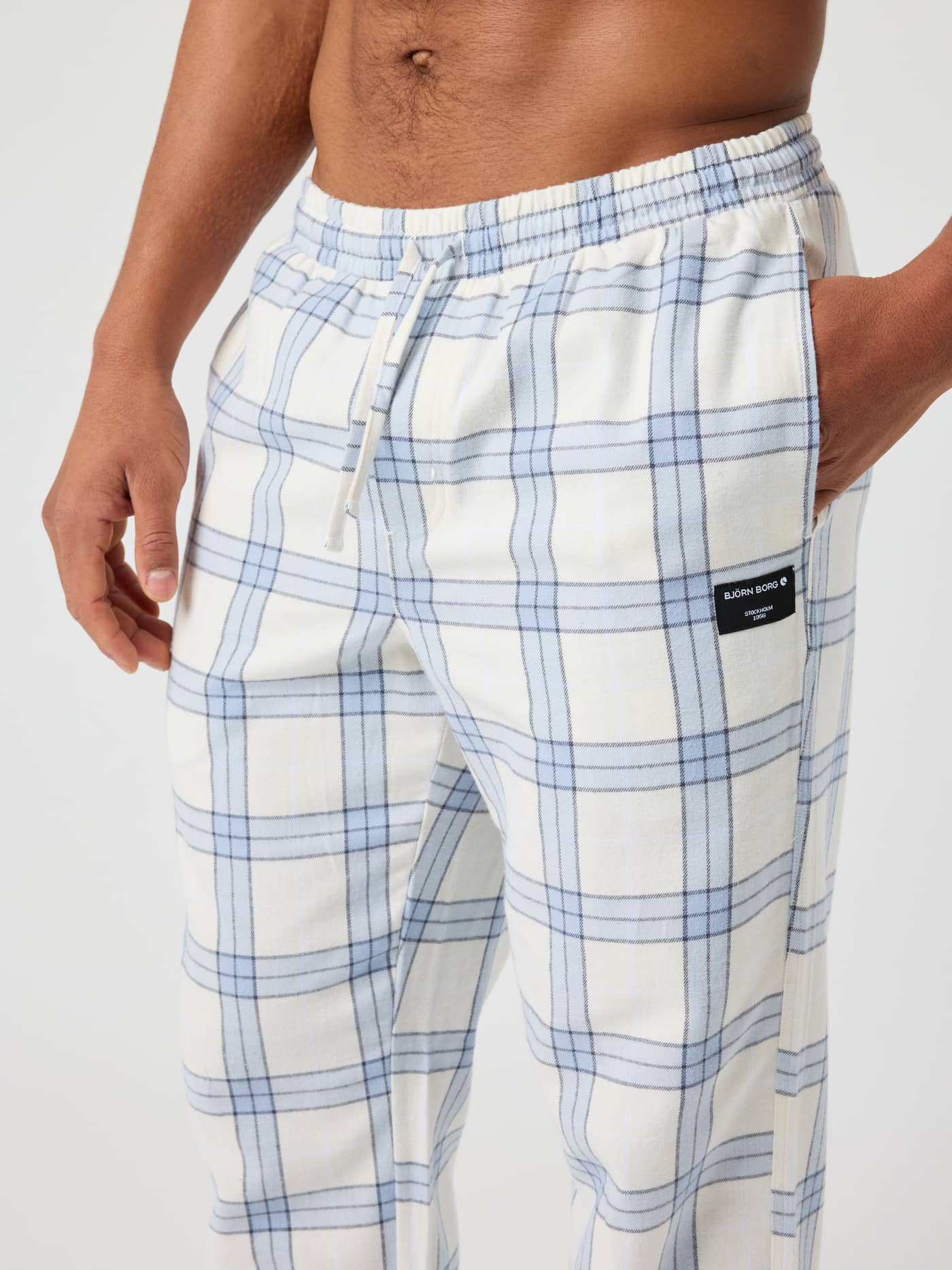 Close-up of the Core Flannel Pyjama Pants in tartan, showing the waistband and side pocket with label. - Image 4