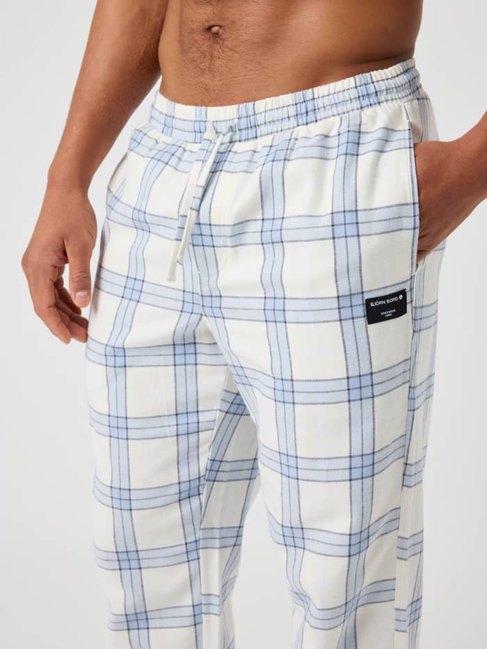 Close-up of the Core Flannel Pyjama Pants in tartan, showing the waistband and side pocket with label.