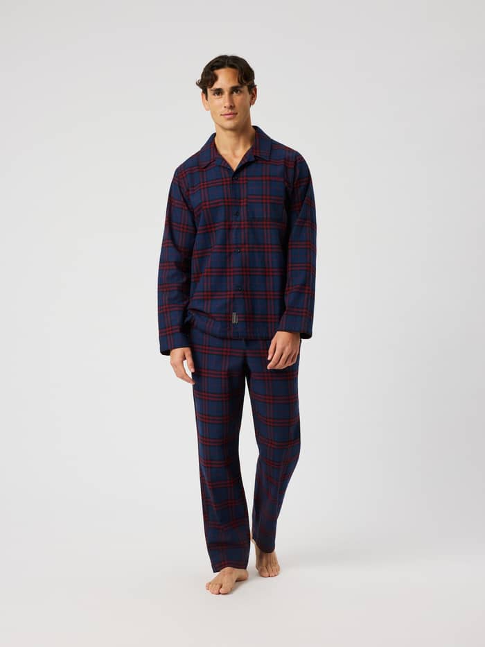 Front view of a model wearing the Core Flannel Pyjama Pants in a blue and red tartan plaid pattern.