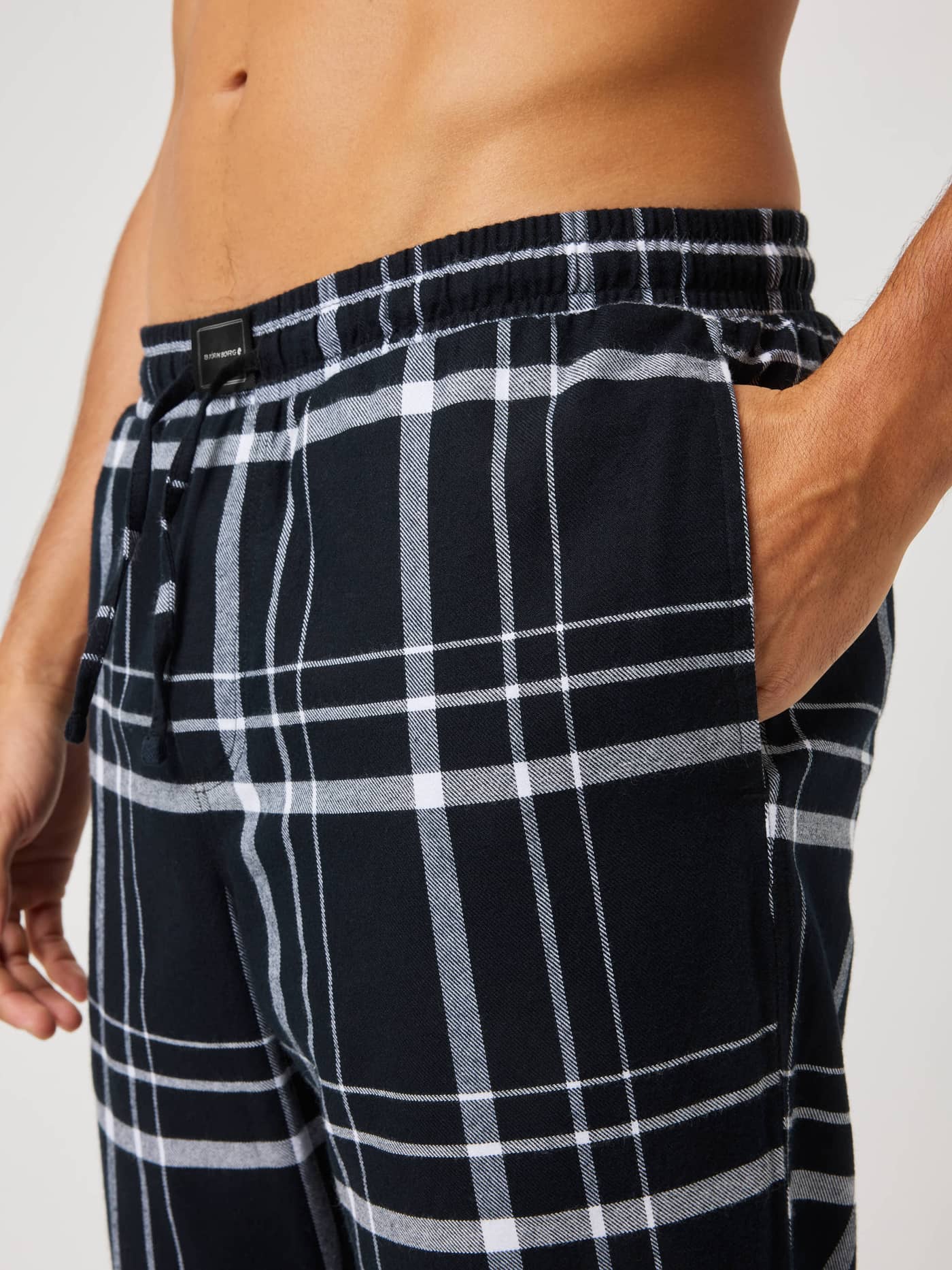 Core Flannel Pyjama Pants in Lounge Pattern (Black, Grey, White) featuring a brushed flannel check and black logo label. - Image 5