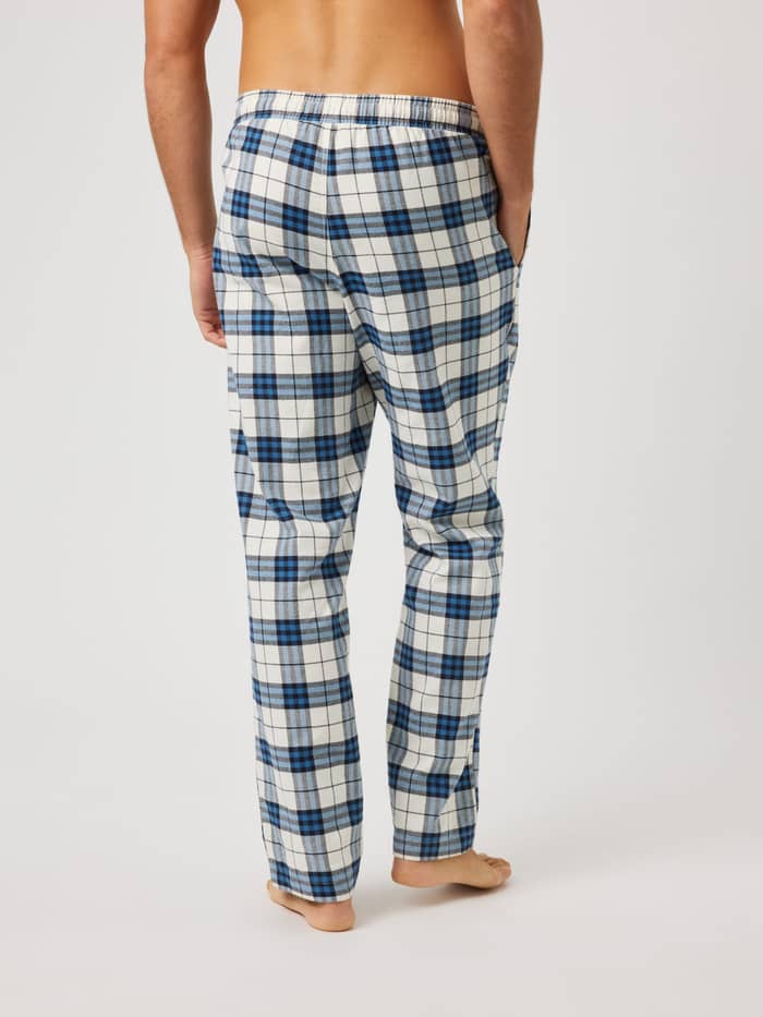 Rückansicht eines Mannes in Core Flannel Pyjama Pants mit Karomuster in Blau, Weiß und Schwarz aus weichem Flanell. - Image 2