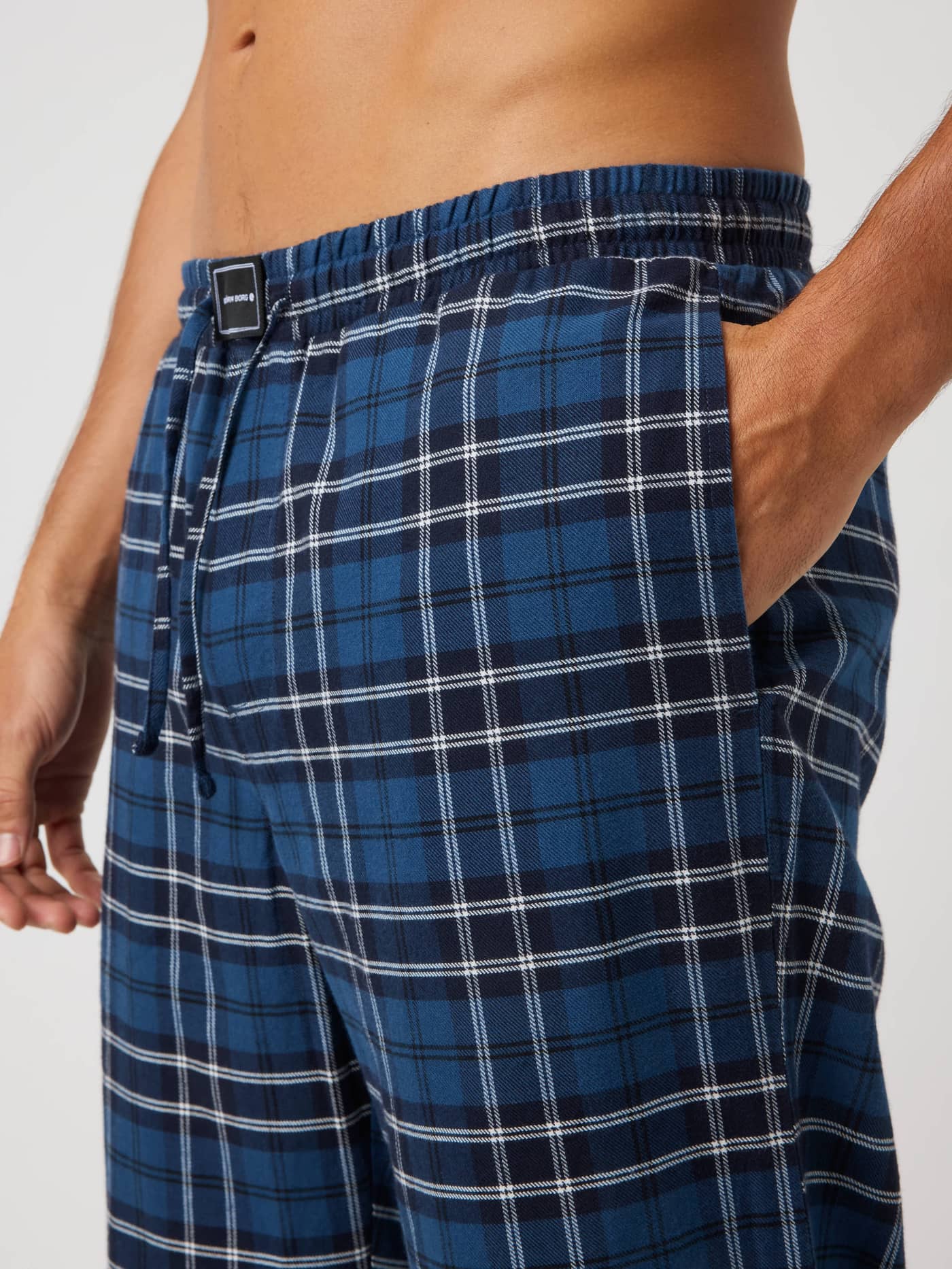 Core Flannel Pyjama Pants in Forest Tartan 4 (Green) with a classic check pattern, side pocket, and black logo patch. - Image 4