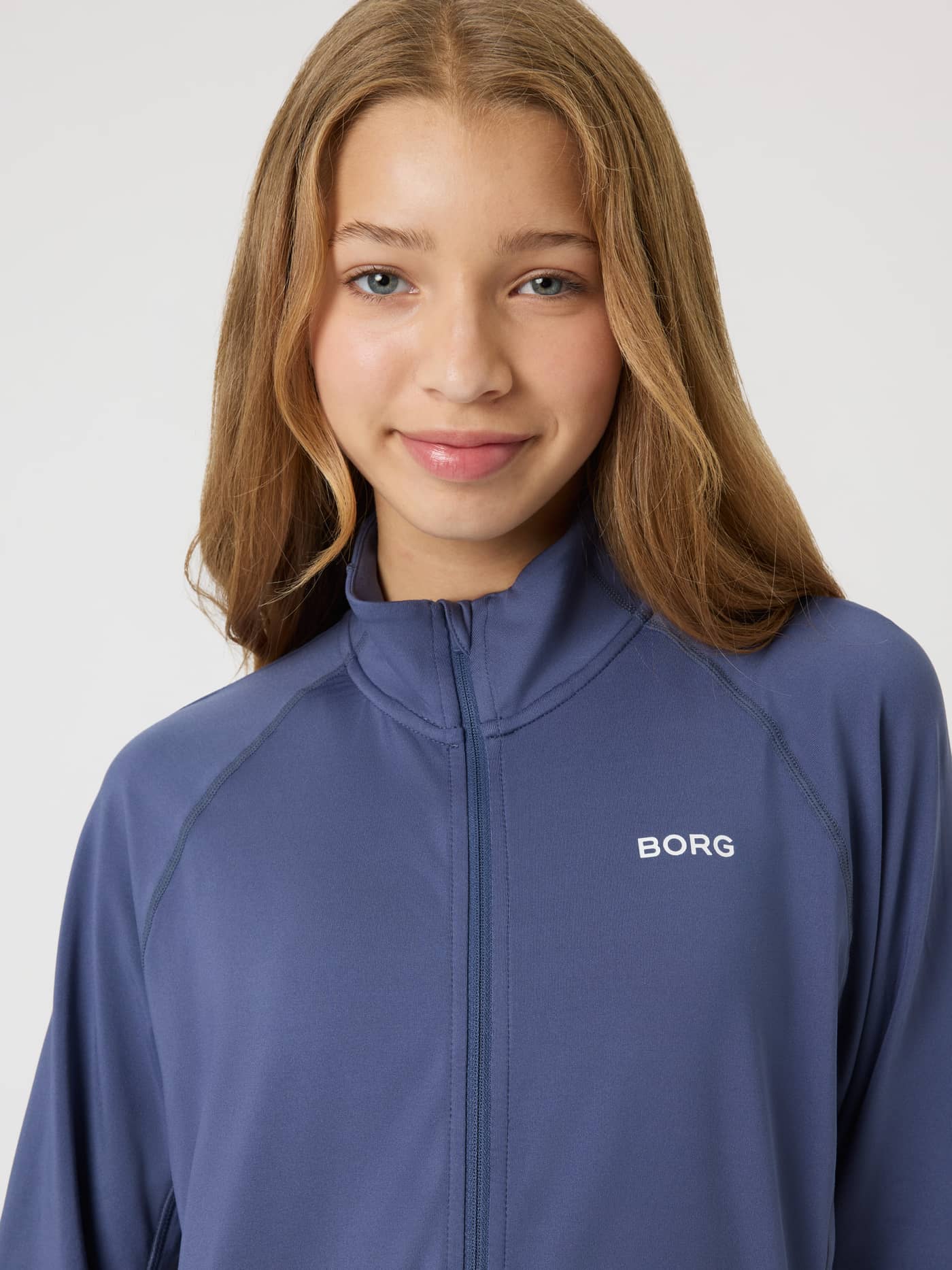 Nærbilde forfra av et barn i Borg Full Zip Midlayer i Nightshadow Blue (Blå), en treningstopp for barn. - Image 4