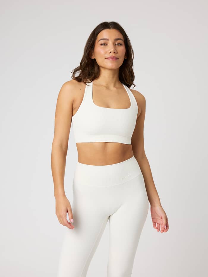 Studio Ribbed Racerback Bra i Tofu (Vit) på en modell med en premium ribbad textur, perfekt för träning.