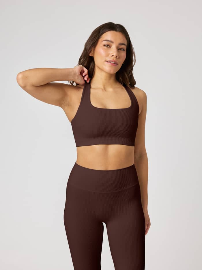 Studio Ribbed Racerback Bra i Coffee Bean (Brun) sedd framifrån med ribbad textur och tonal logo för träning.