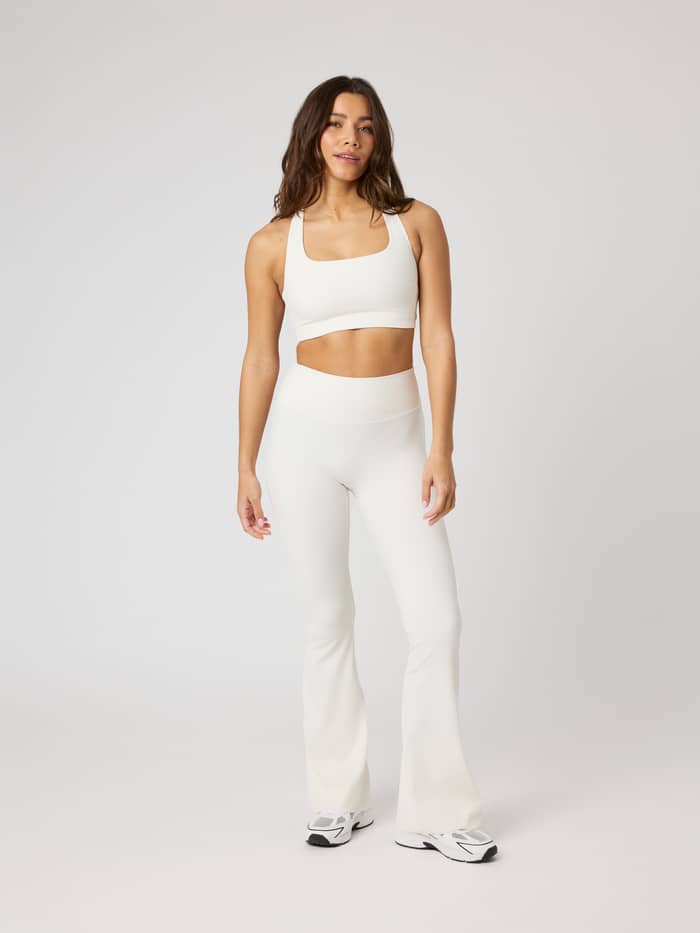 Studio Ribbed Racerback Bra i Tofu (Vit) sedd framifrån i helfigur på en modell för premium träning. - Image 4
