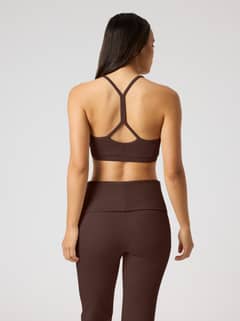 Back view of a model wearing the Studio Flow Racerback Bra in Coffee Bean (Brown) for yoga and training sessions. - Image 3
