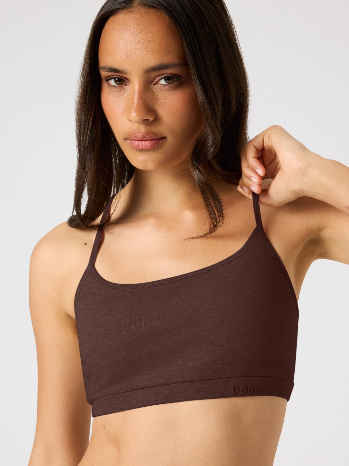 Front view of the Studio Flow Racerback Bra in Brown with thin straps and a tonal BORG logo for yoga and training. - Image 5