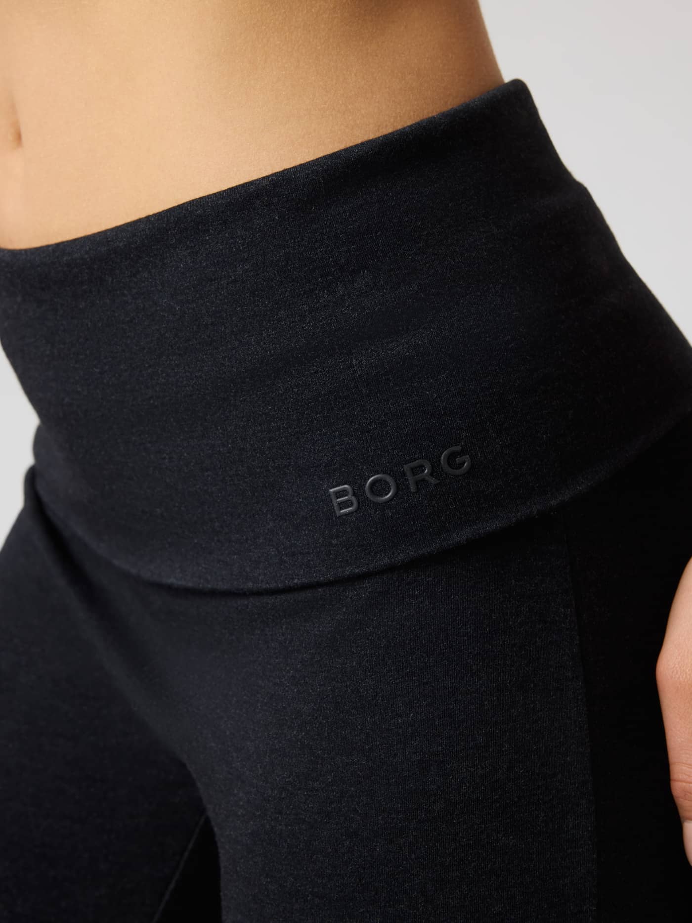 Close-up of Studio Flow Folded Wide Pants in Black Beauty (Black) with a folded waistband and black Borg logo for training. - Image 5
