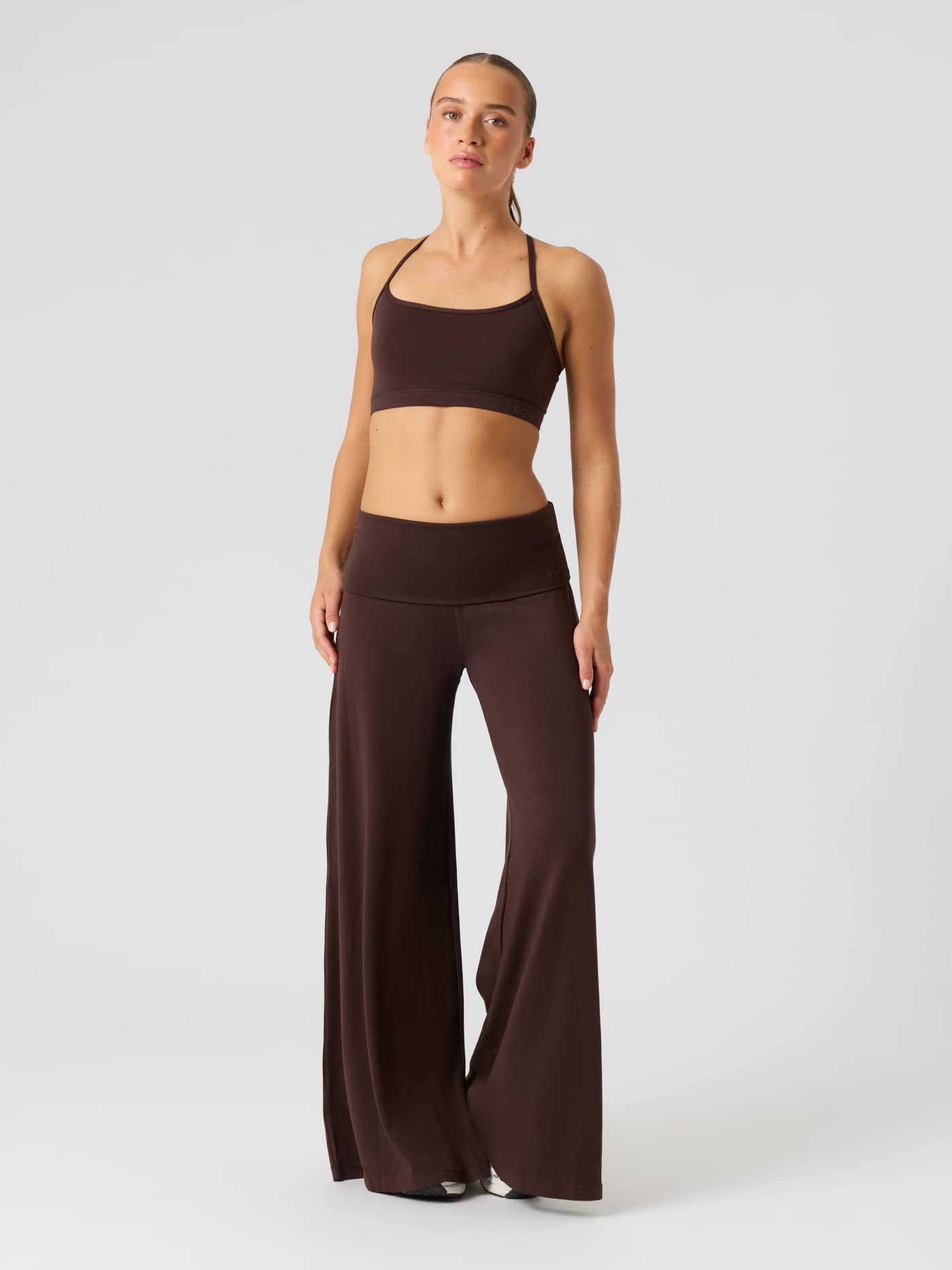 Vorderansicht einer Modelldarstellung der Studio Flow Folded Wide Pants in Coffee Bean (Braun) mit umklappbarem hohem Bund. - Image 1