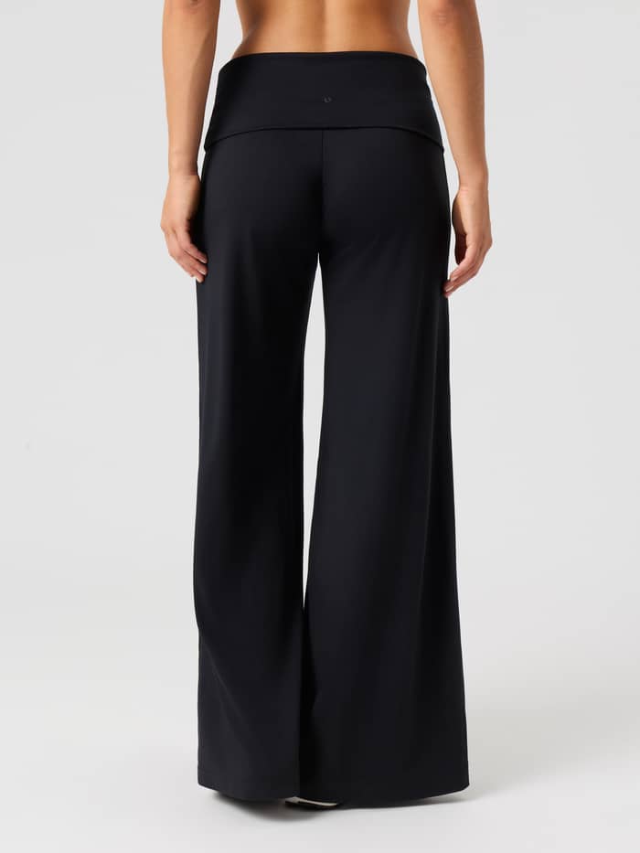 Achteraanzicht van de Studio Flow Folded Wide Pants in Black Beauty (zwart) met de focus op het wijde model. - Image 4