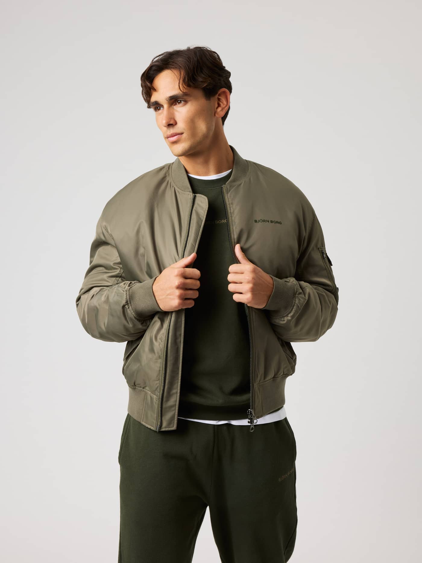 Borg Bomber Jacket i Kalamata (Grønn) med svart logo, sett forfra til oppvarming og trening. - Image 1