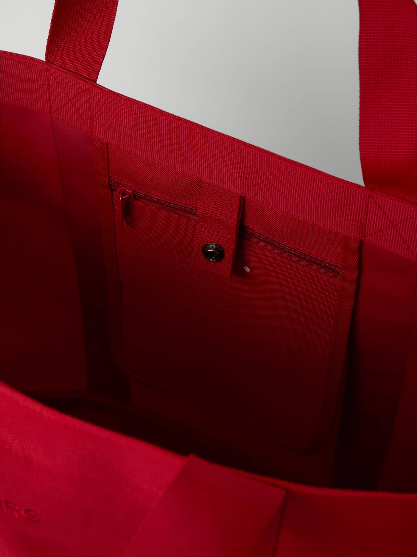 Borg Day To Day Tote L - 20L in Samba (Red) showing the inner zip pocket and snap button closure for training. - Image 4