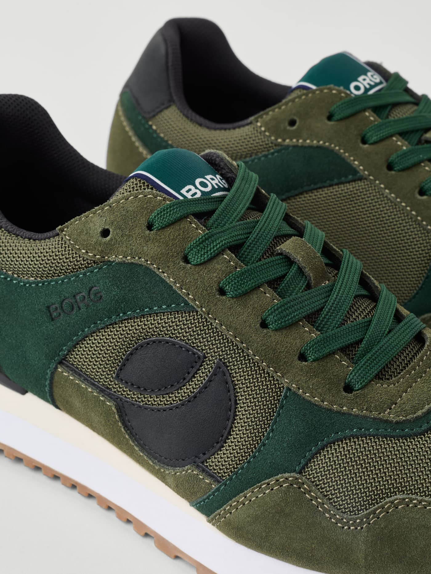 Close-up of Men's Pulse Sneakers in Green featuring suede, mesh panels, and a black logo for a premium running style. - Image 4