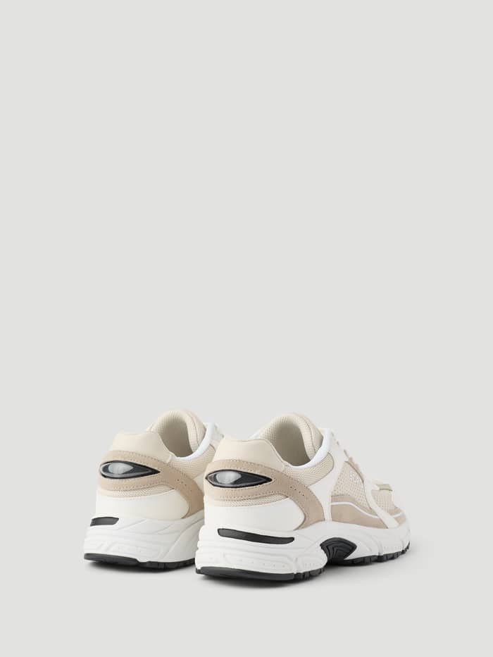 Achteraanzicht van de Women's Alley Sneakers in Beige met een running-geïnspireerd design en zwart logo op de hiel. - Image 3