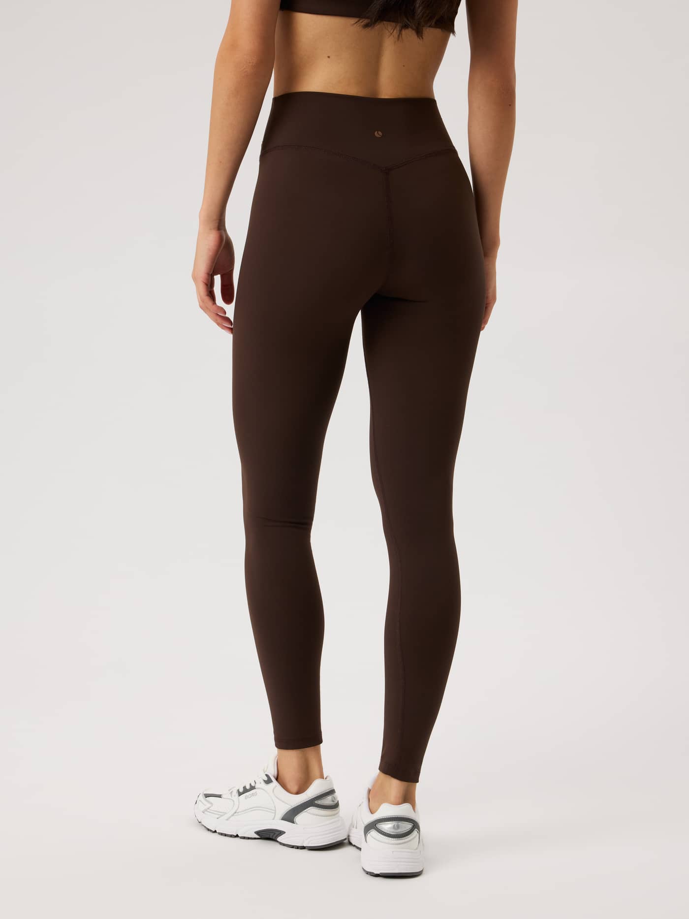 Vue arrière du Studio Essence Tights en Coffee Bean (Brun) à taille haute avec logo ton sur ton pour le training. - Image 3