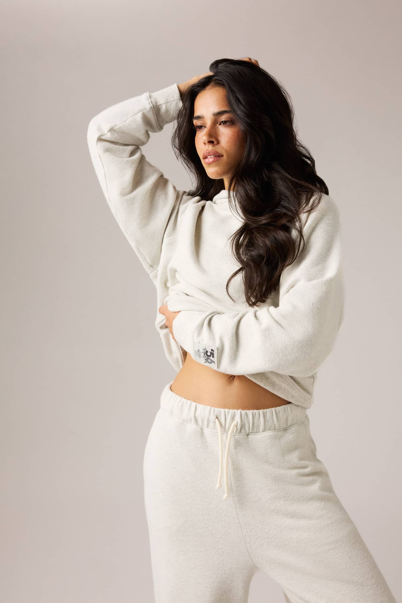 Studio French Terry Oversized Hoodie in Tofu Melange (Beige) on a model, featuring an oversized fit for studio warm-ups. - Image 1