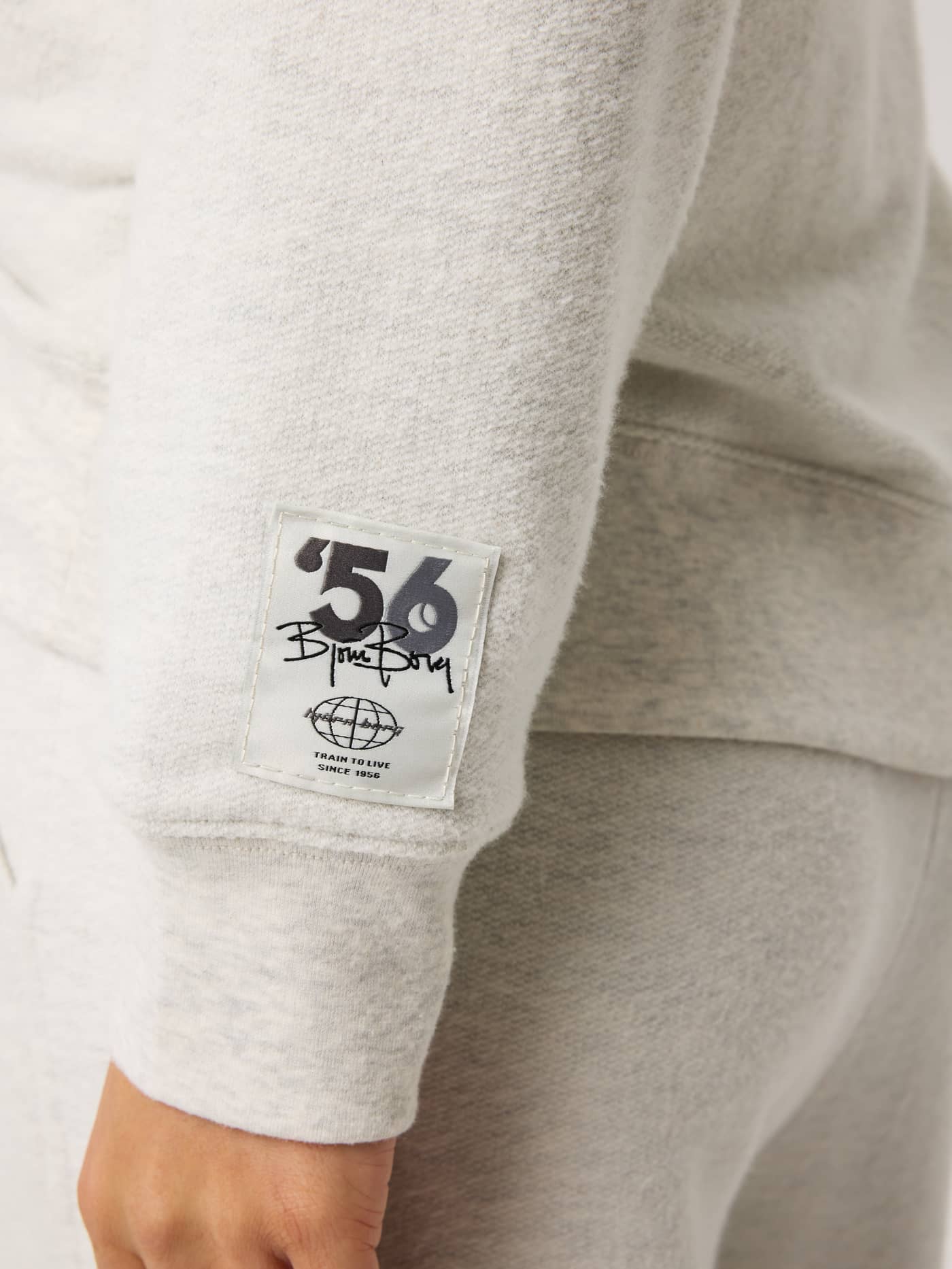 Studio French Terry Oversized Hoodie in Tofu Melange (Beige) featuring a detailed tennis logo patch on the sleeve. - Image 5