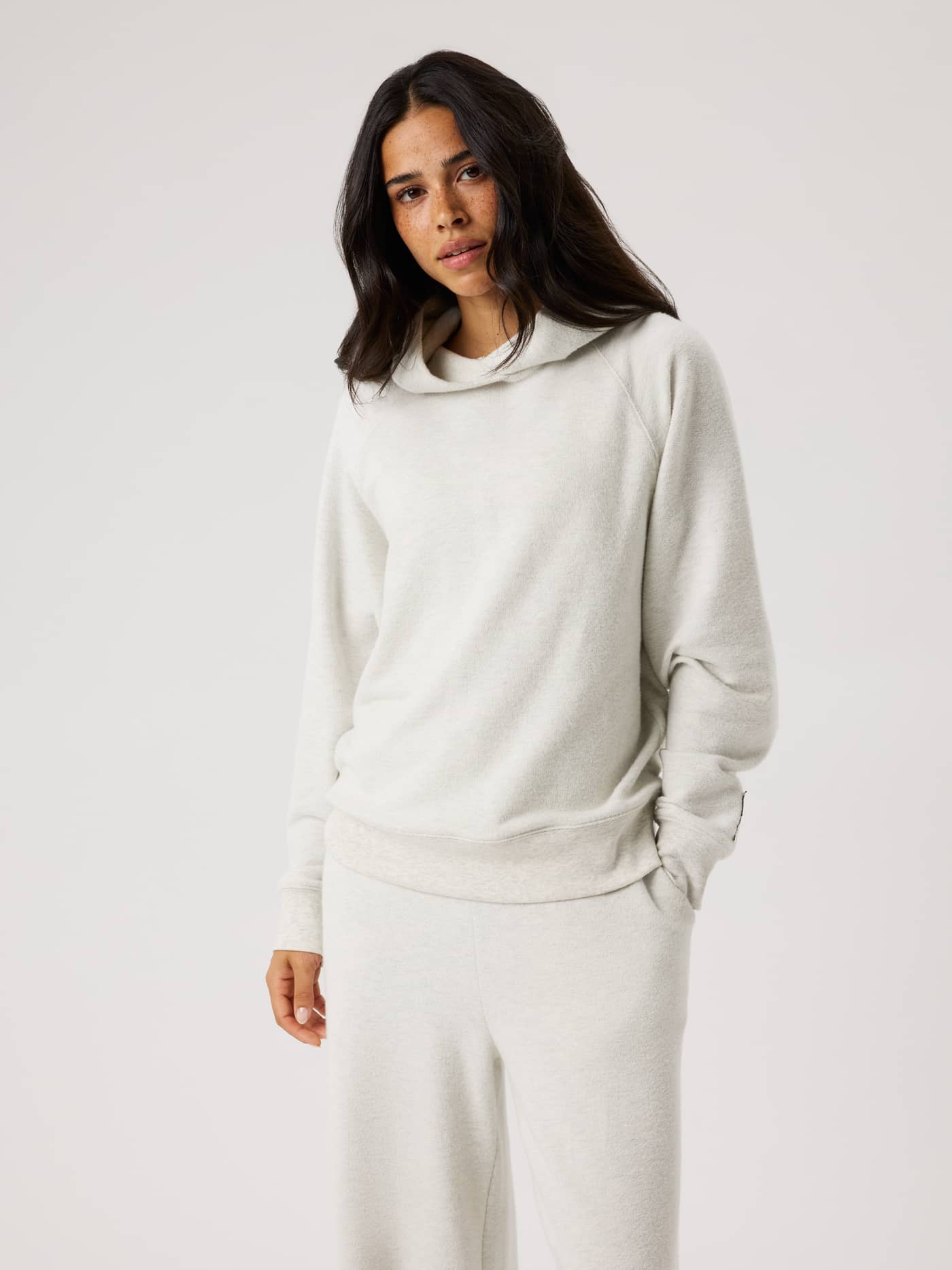Front view of a model wearing the Studio French Terry Oversized Hoodie in Tofu Melange (Beige) for studio training. - Image 2