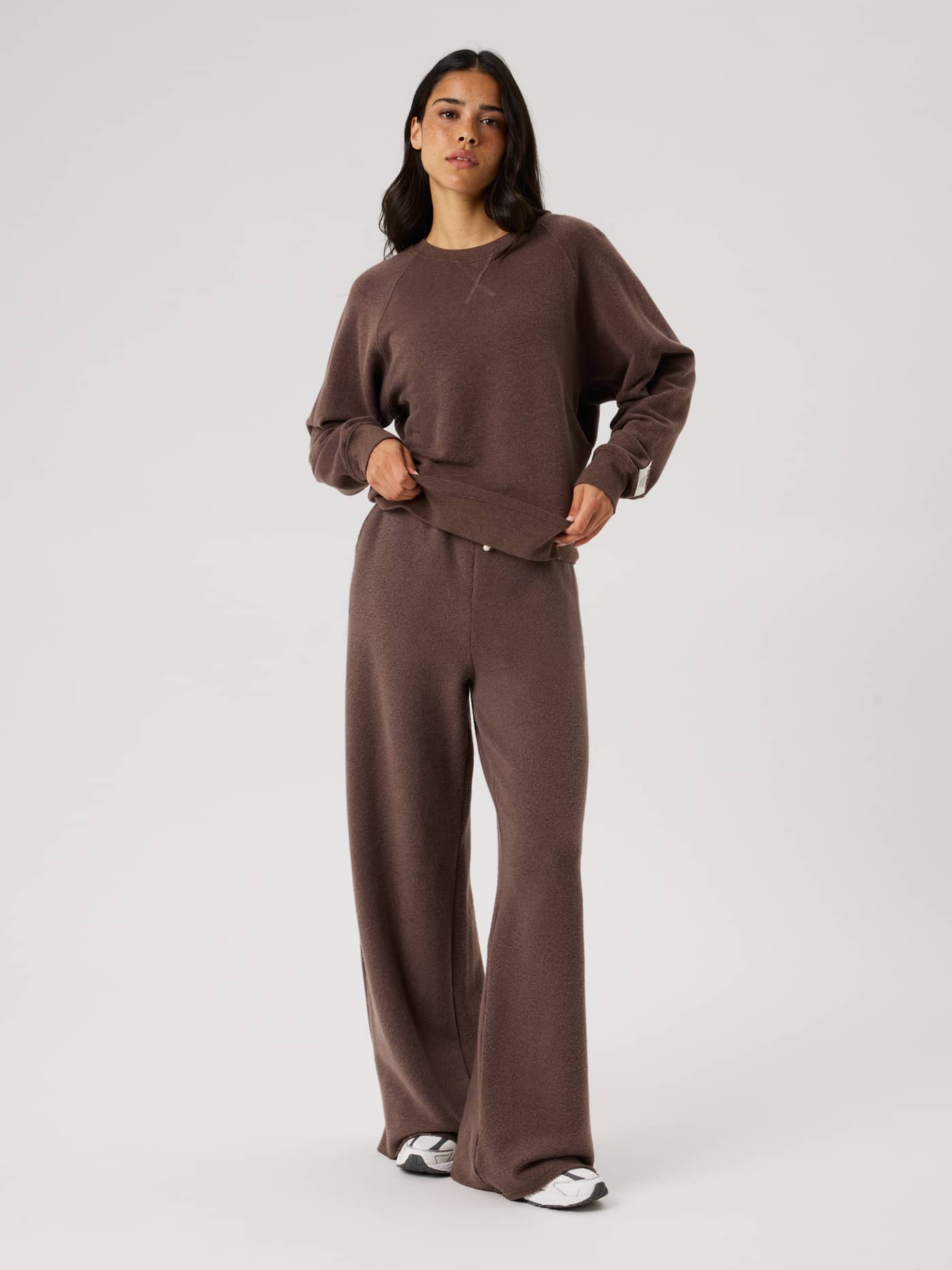 Full-body view of the Studio French Terry Oversized Sweatshirt in Brown Melange (Brown) with a white logo on the sleeve. - Image 4