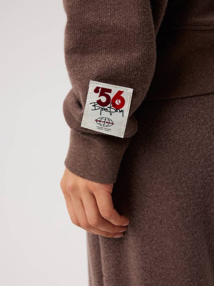 Close-up van de Studio French Terry Oversized Sweatshirt in Brown Melange (Bruin) met een witte heritage tennislogopatch. - Image 5
