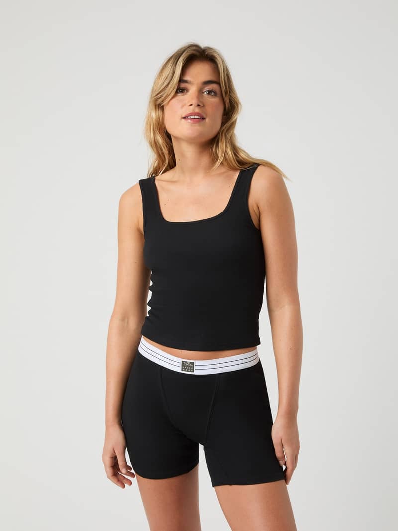 Front view of a model wearing the Core Original Rib Tank in Black Beauty (Black) with a slim fit and soft rib texture.
