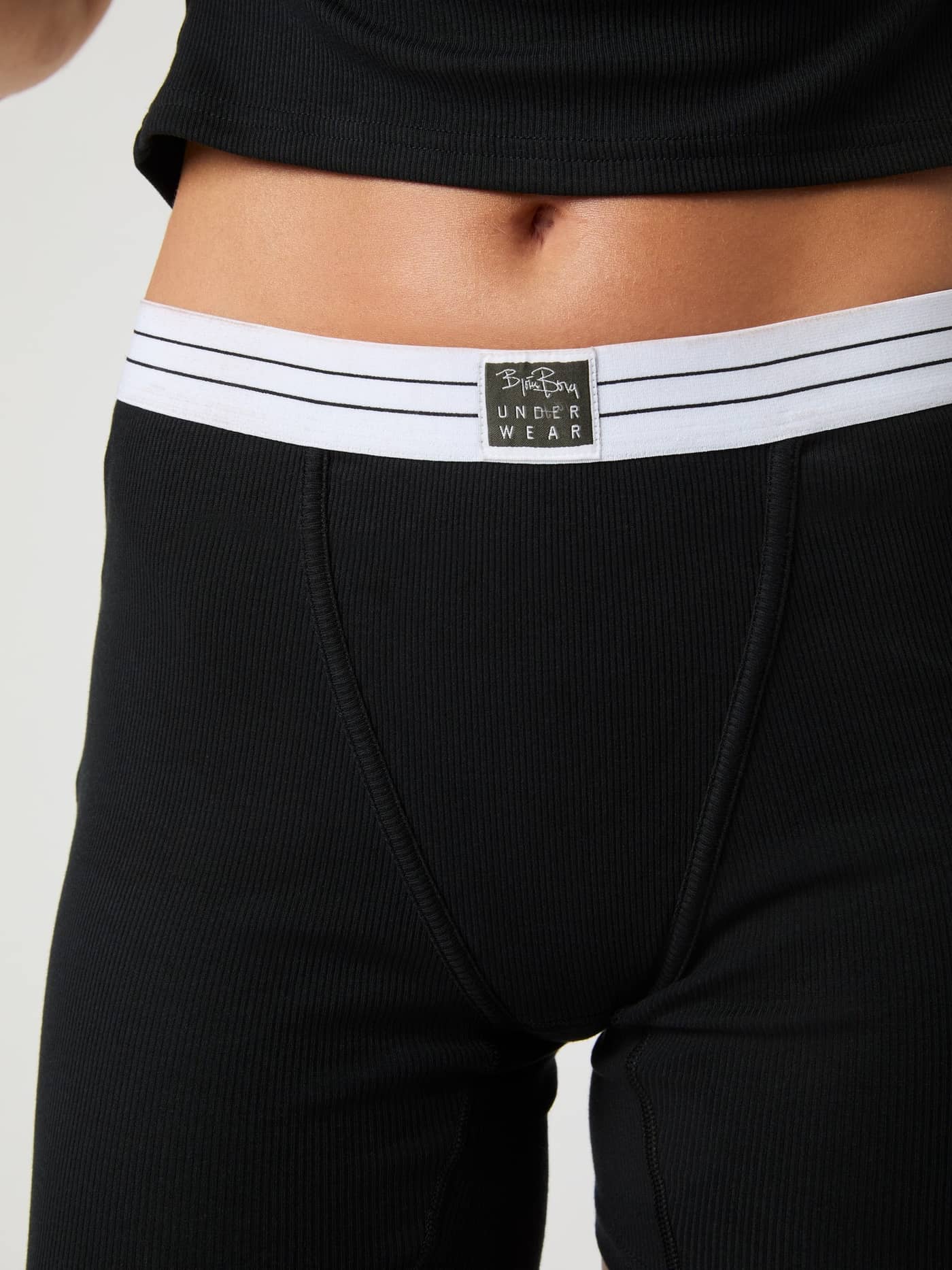 Close-up of the Core Original Rib Boxers in Black with ribbed cotton and a white striped waistband with a black logo. - Image 4