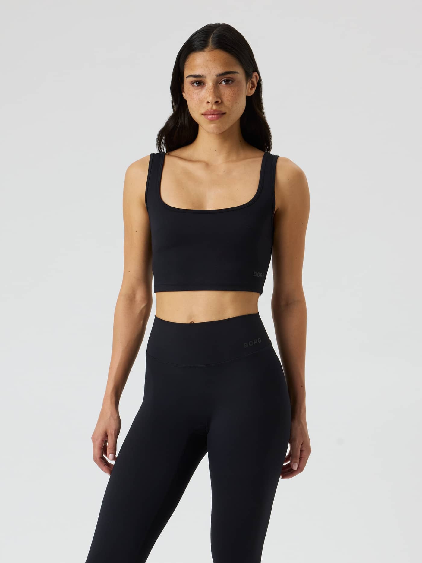 Vooraanzicht van de Studio Essence Crop Tank Top in Black Beauty (Zwart) voor training met een tonaal logo. - Image 3
