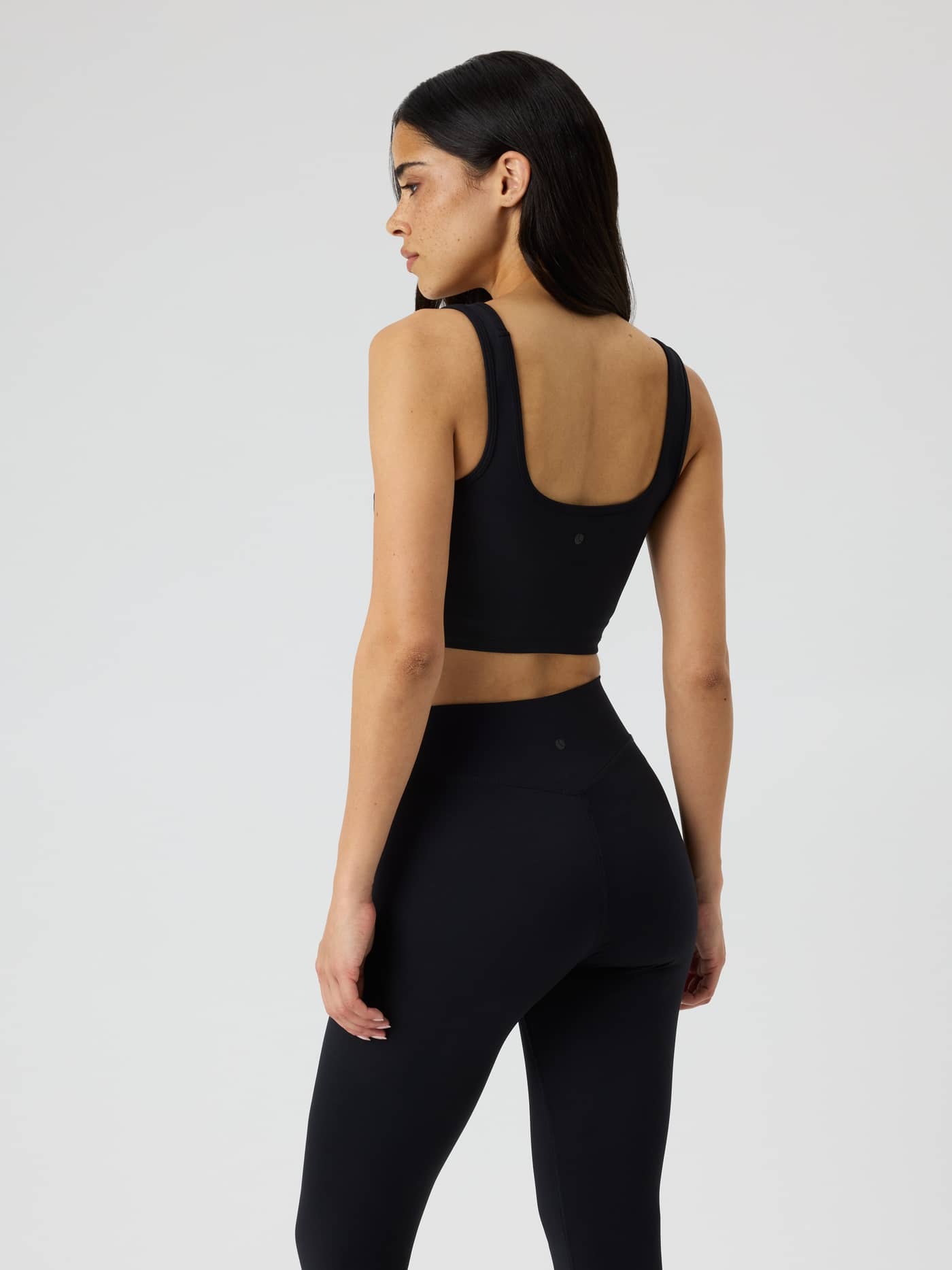 Achteraanzicht van de Studio Essence Crop Tank Top in Black Beauty (Zwart) voor training met nauwsluitende cropped pasvorm. - Image 4