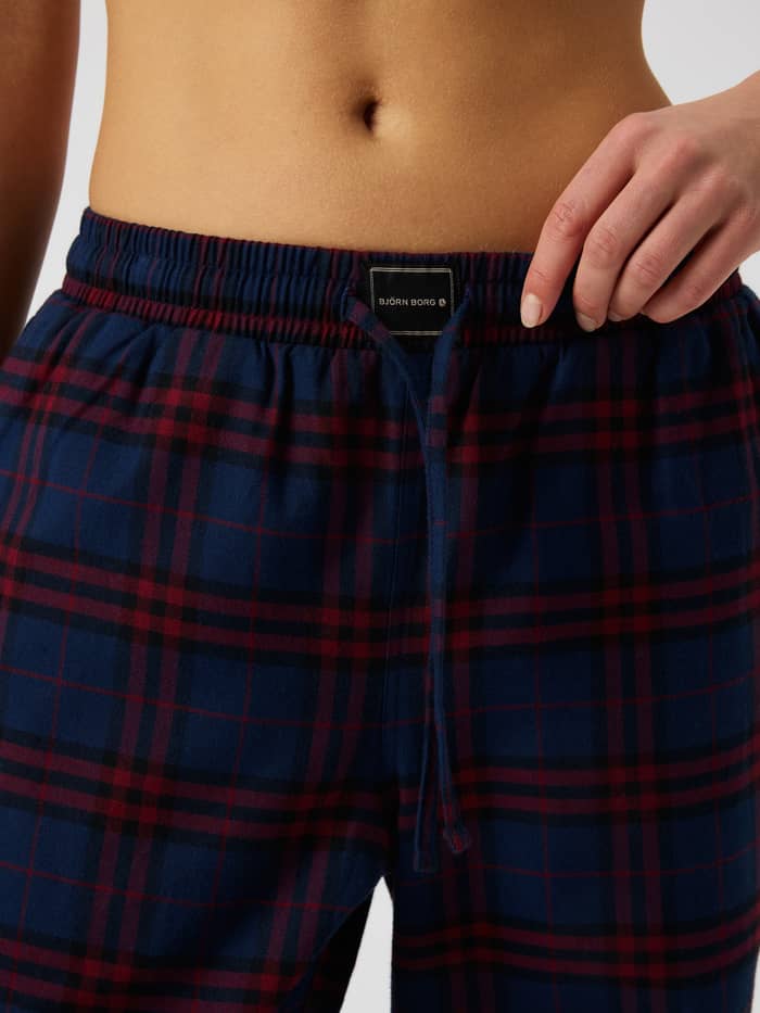 Close-up of the Core Flannel Pyjama Pants in tartan plaid with an elastic waistband and a black logo label.