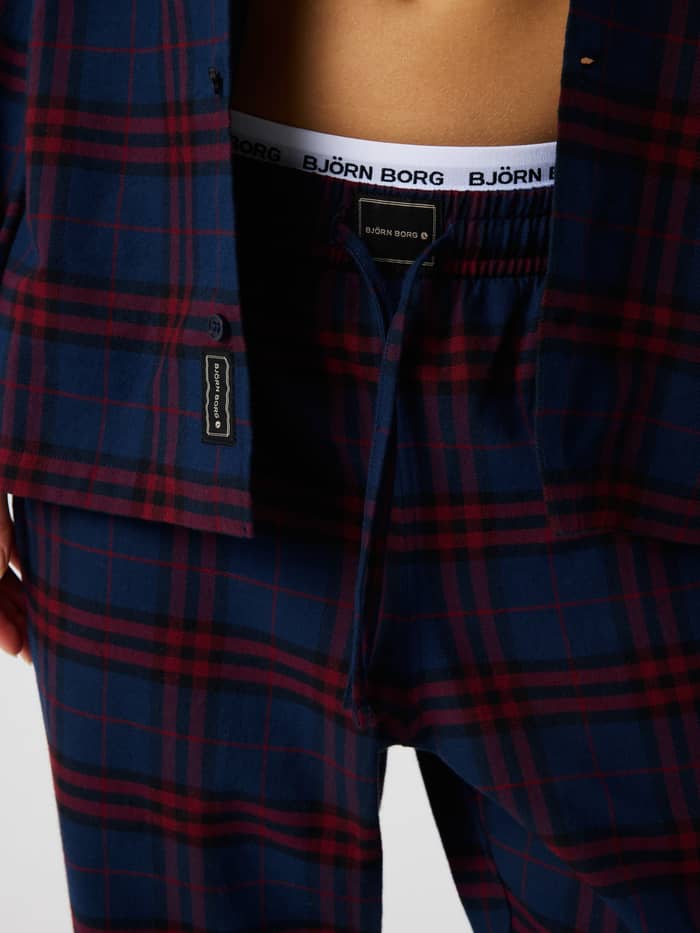 Close-up of the Core Flannel Pyjama Shirt in a blue and red tartan check with button closure and drawstring waistband.