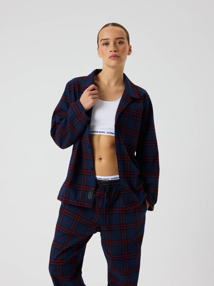Front view of a female model wearing the Core Flannel Pyjama Shirt in a blue and red tartan pattern.