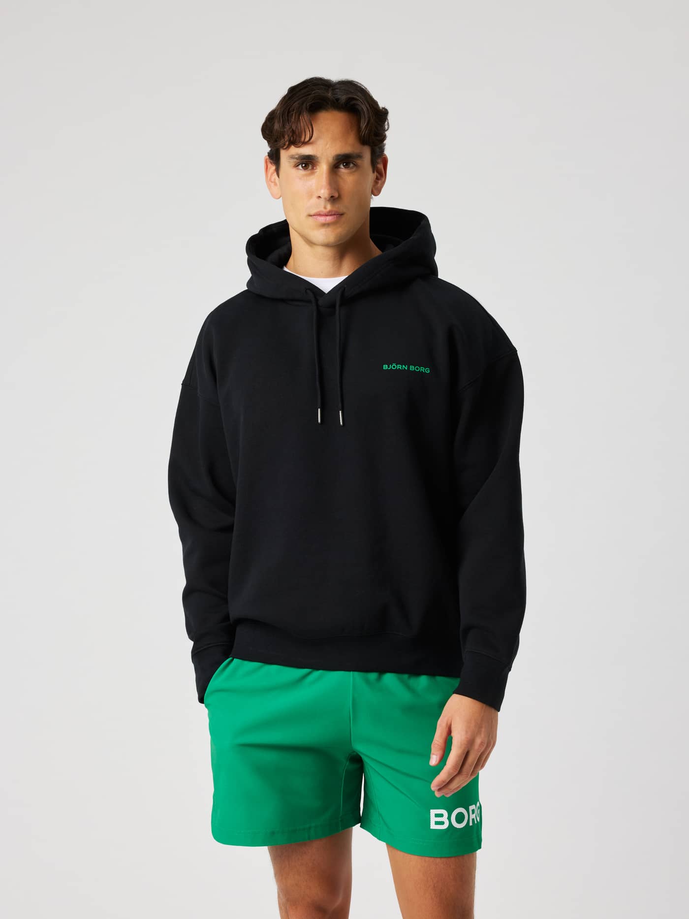 Front view of the Borg Oversized Hoodie in Black Beauty (black) with a green logo. - Image 2