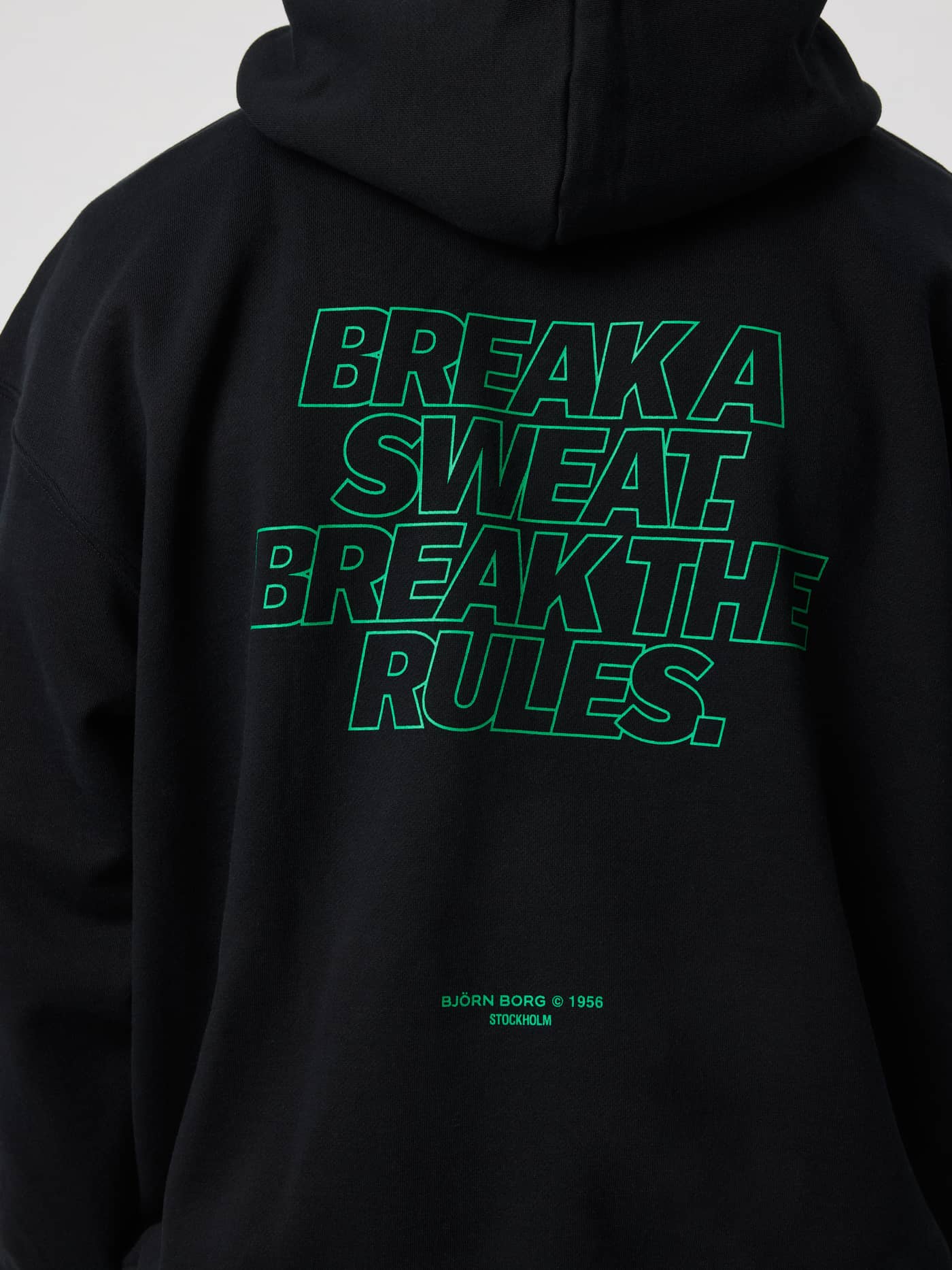 Back view of the Borg Oversized Hoodie in black beauty featuring green text print on the back. - Image 5