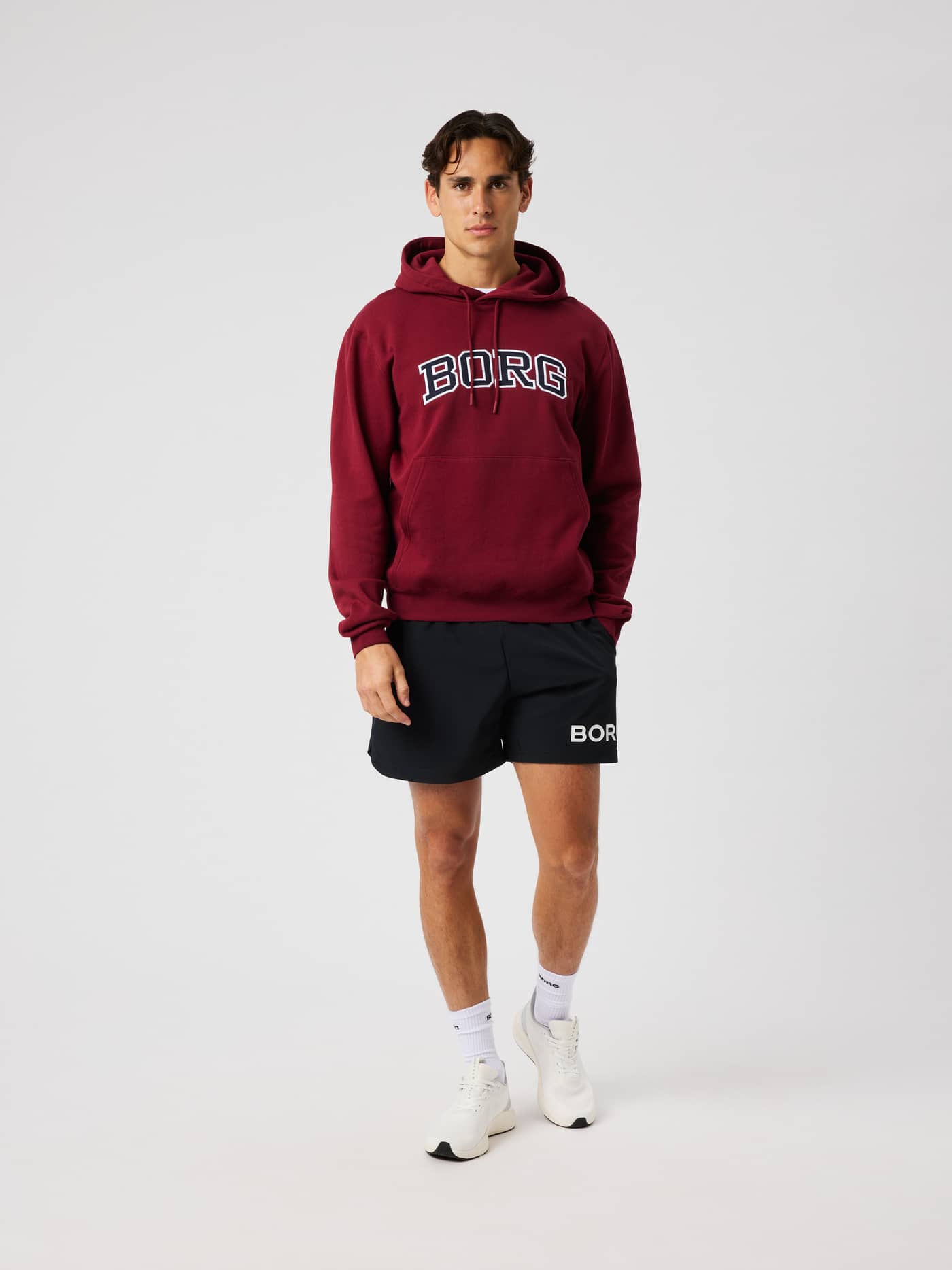 Male model wearing the Borg Classic Print Hoodie in Cabernet (burgundy) featuring a white logo on the chest. - Image 3