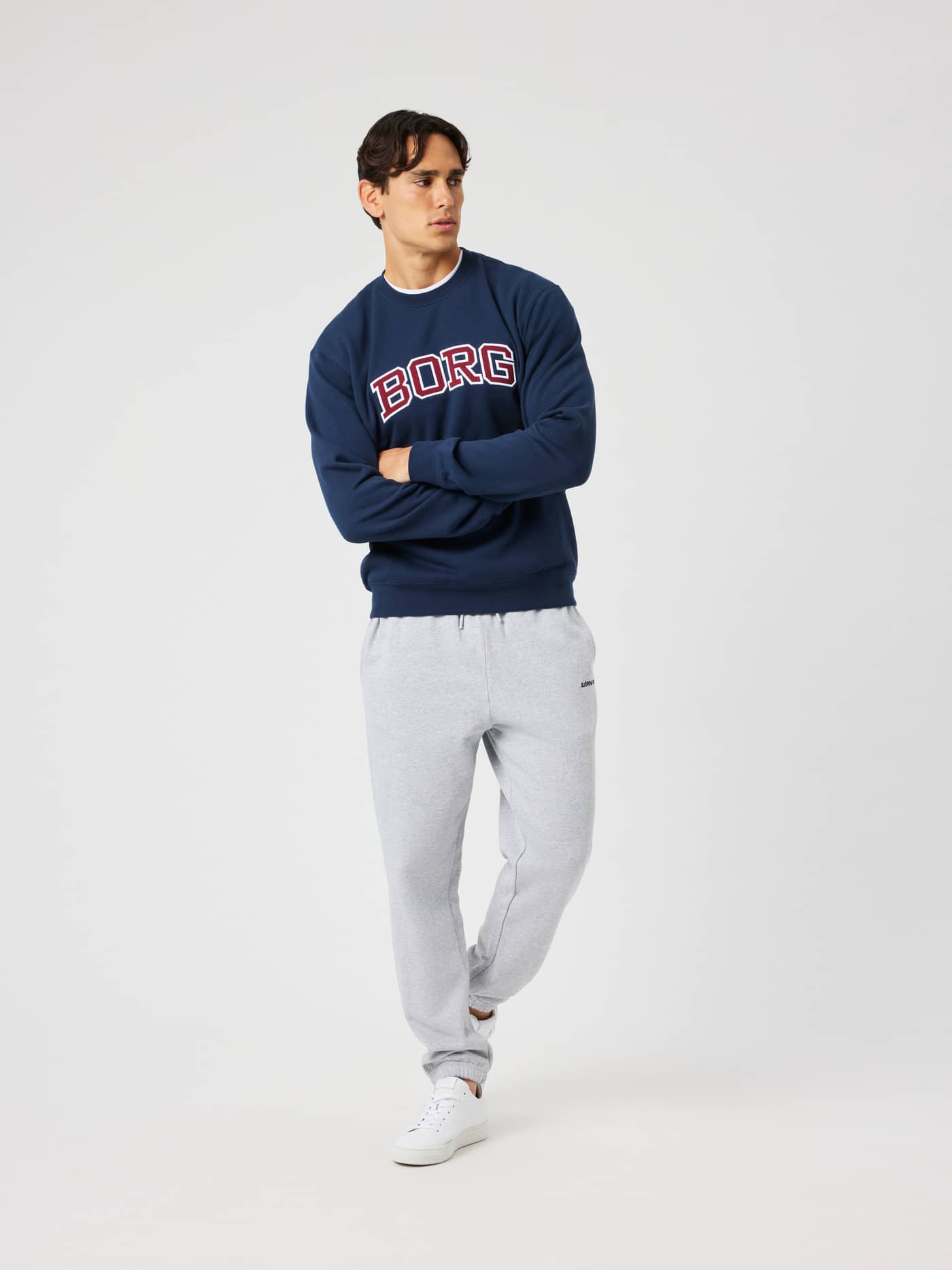 Male model wearing the Borg Classic Print Sweatshirt in Dress Blues (navy) featuring a red and white BORG logo on the chest. - Image 4